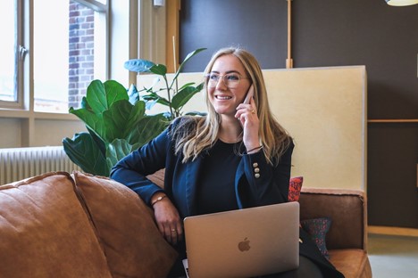 Woman on phone using Macbook laptop