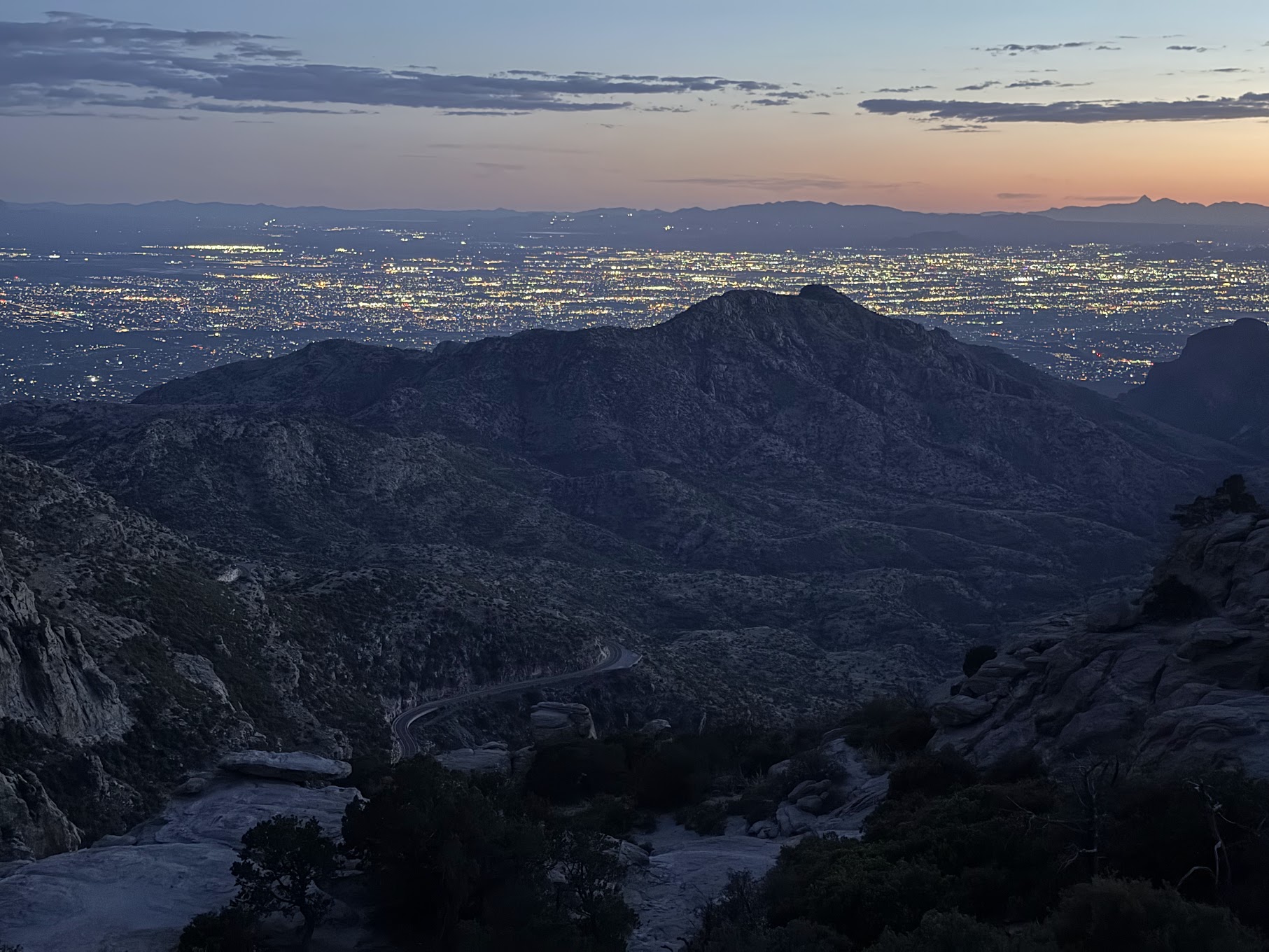 Tucson city lights below the mountains at dusk