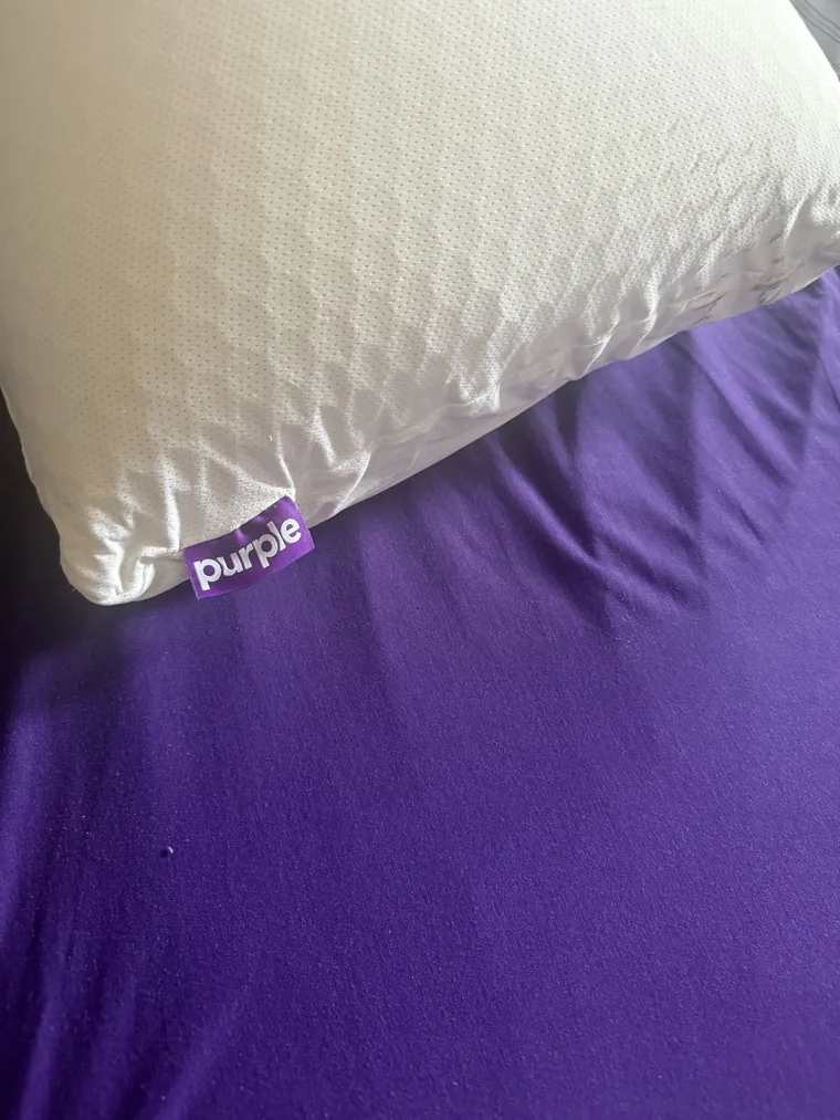 Close-up of one of our white Purple pillows with a purple pillowcase beside it