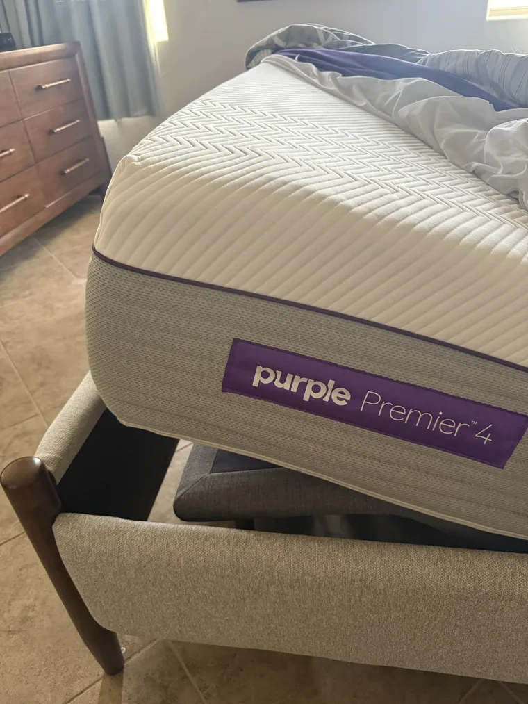 Side label reading Purple Premier 4 on our king mattress, with adjustable base visible below